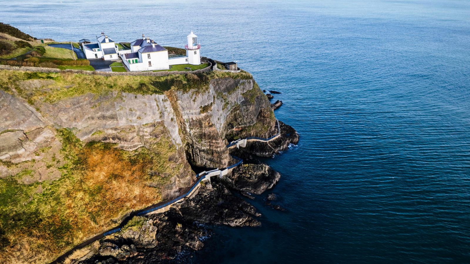 Drone view of Blackhead Lighthouse and coastal path